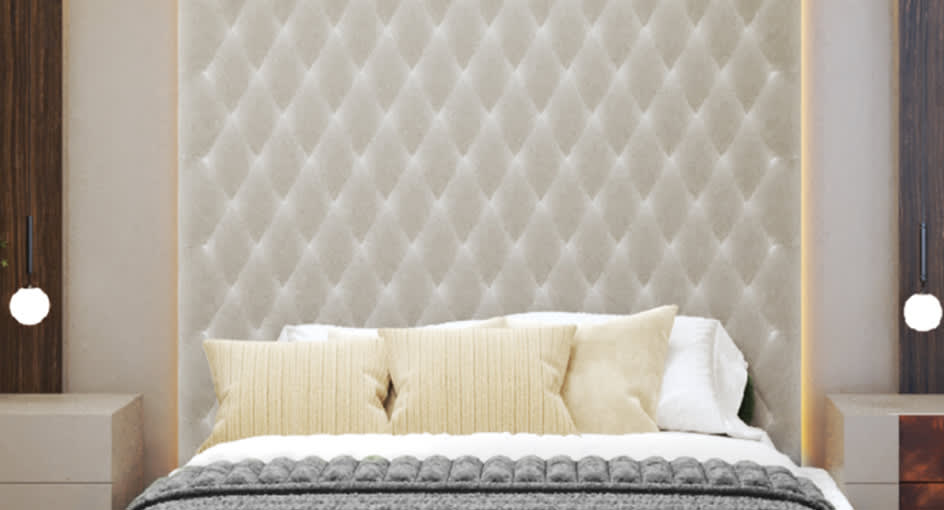 Luxury hotel Deluxe King bedroom with tufted white headboard and warm lighting