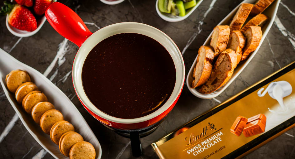 Fondue de chocolate Lindt, com uvas, kiwi, morangos e biscoitos. 